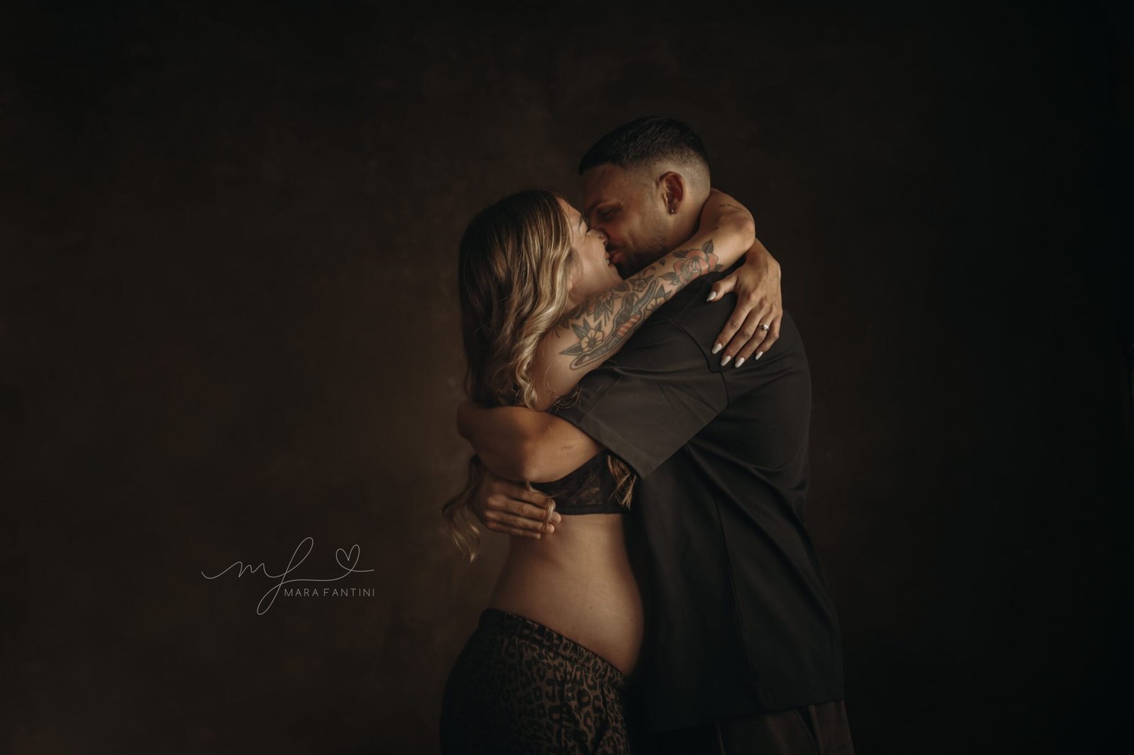 Foto gravidanza Roma — abbraccio intenso tra i futuri genitori, atmosfera intima