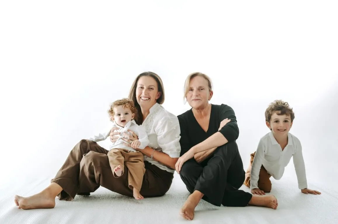 Mamma, nonna e due bambini insieme durante un servizio fotografico di famiglia in studio